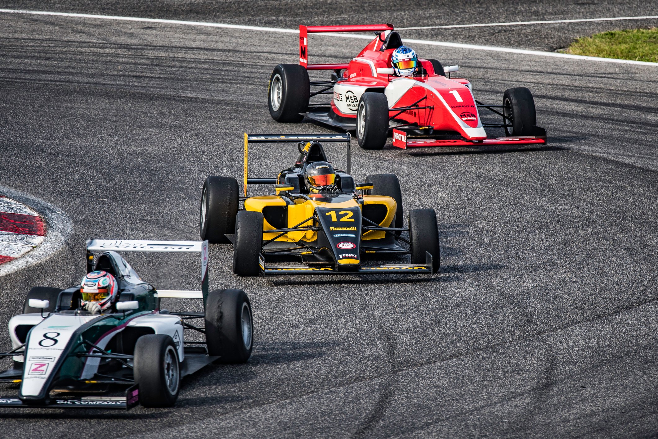 3 race cars circling a track.