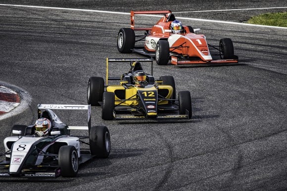 3 race cars running around a track.