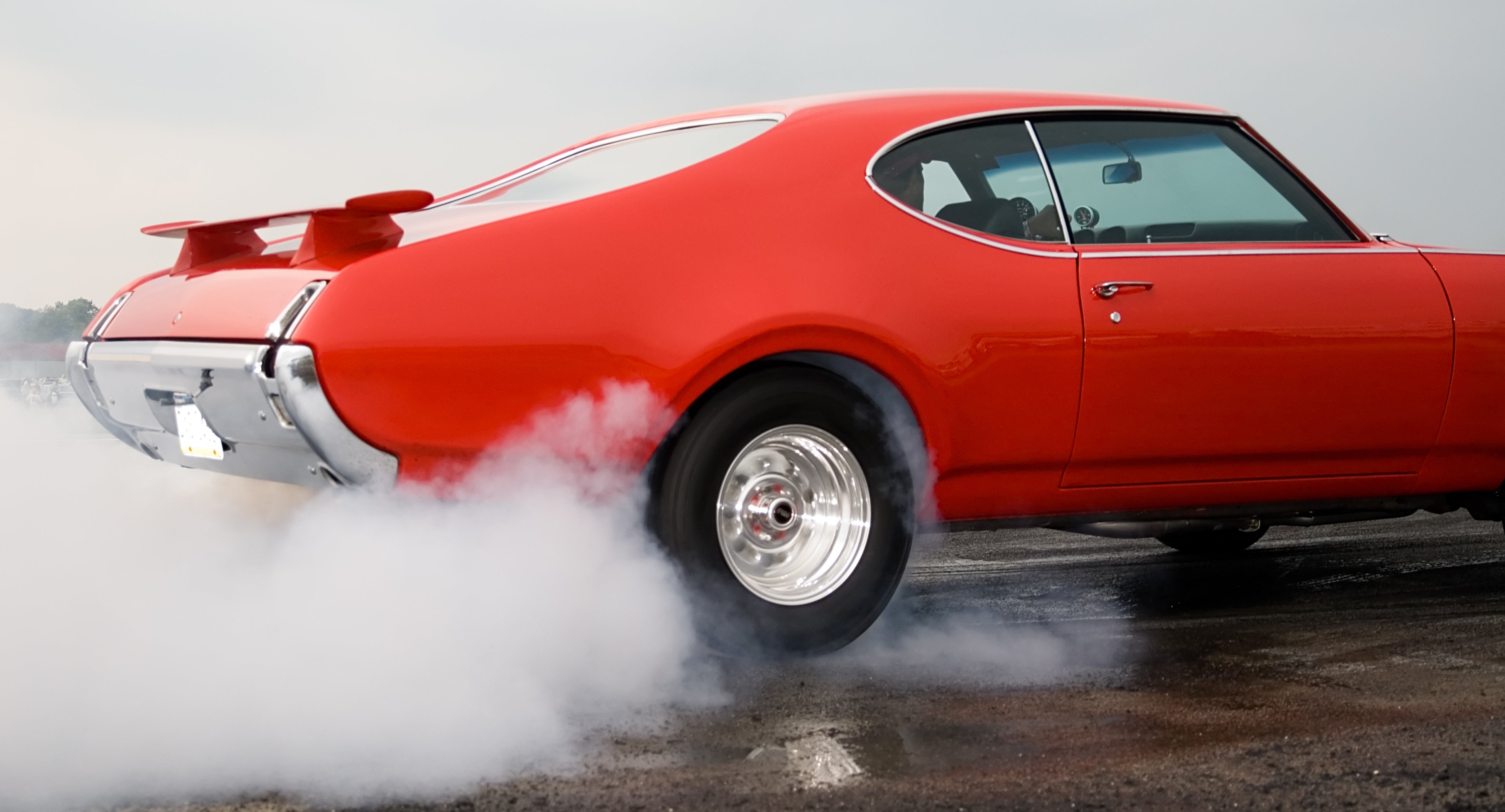 Red muscle car burning rubber
