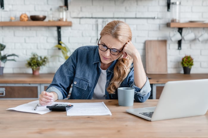 Someone sitting in front of a laptop and calculator.