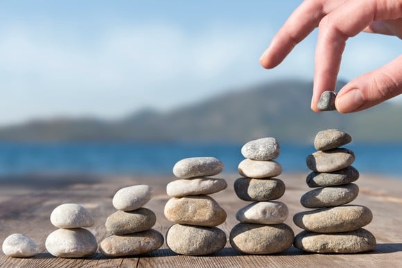 A person stacking stones in increasingly taller towers. 