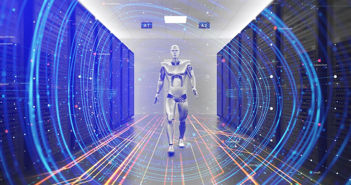 A humanoid robot walks through the aisles of a data center.