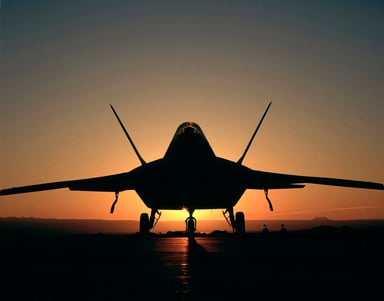 F-22 Raptor silhouetted against a sunrise.
