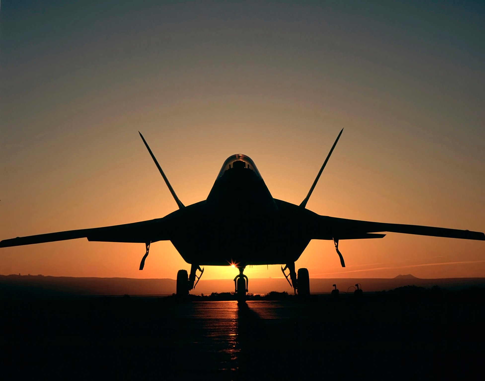 F-22 Raptor silhouetted against a sunrise.