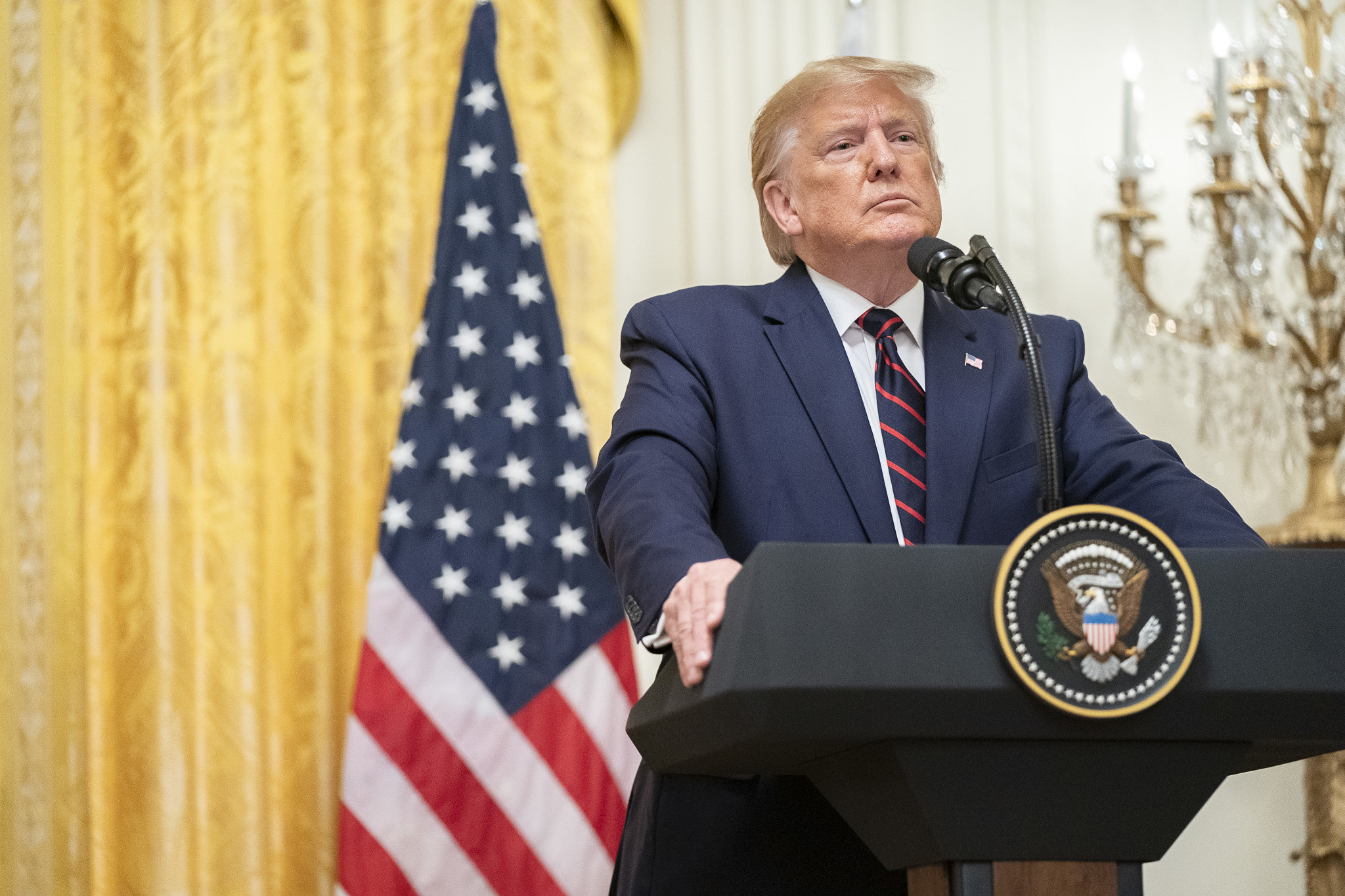 Donald Trump speaking with reporters from the East Room of the White House.