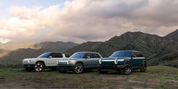 Rivian's electric truck lineup with a mountainous background.