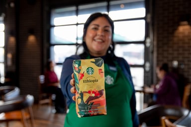 Starbucks worker holding a bag of coffee beans