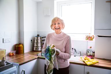 Smiling person drying hands on towel in kitchen