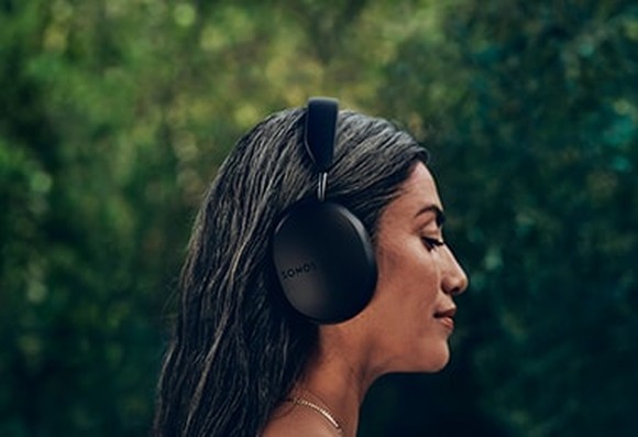 Person listening to Sonos headphones.