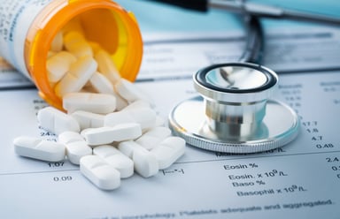 prescription pills spilling stethescope
