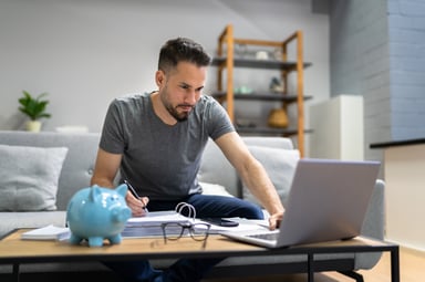 Investor with laptop and piggy bank