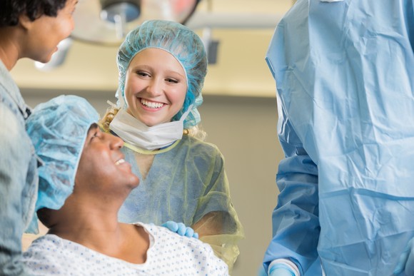 Healthcare workers speak to a patient before surgery.