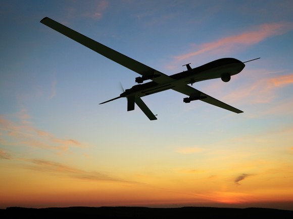 Military drone flying at dawn.