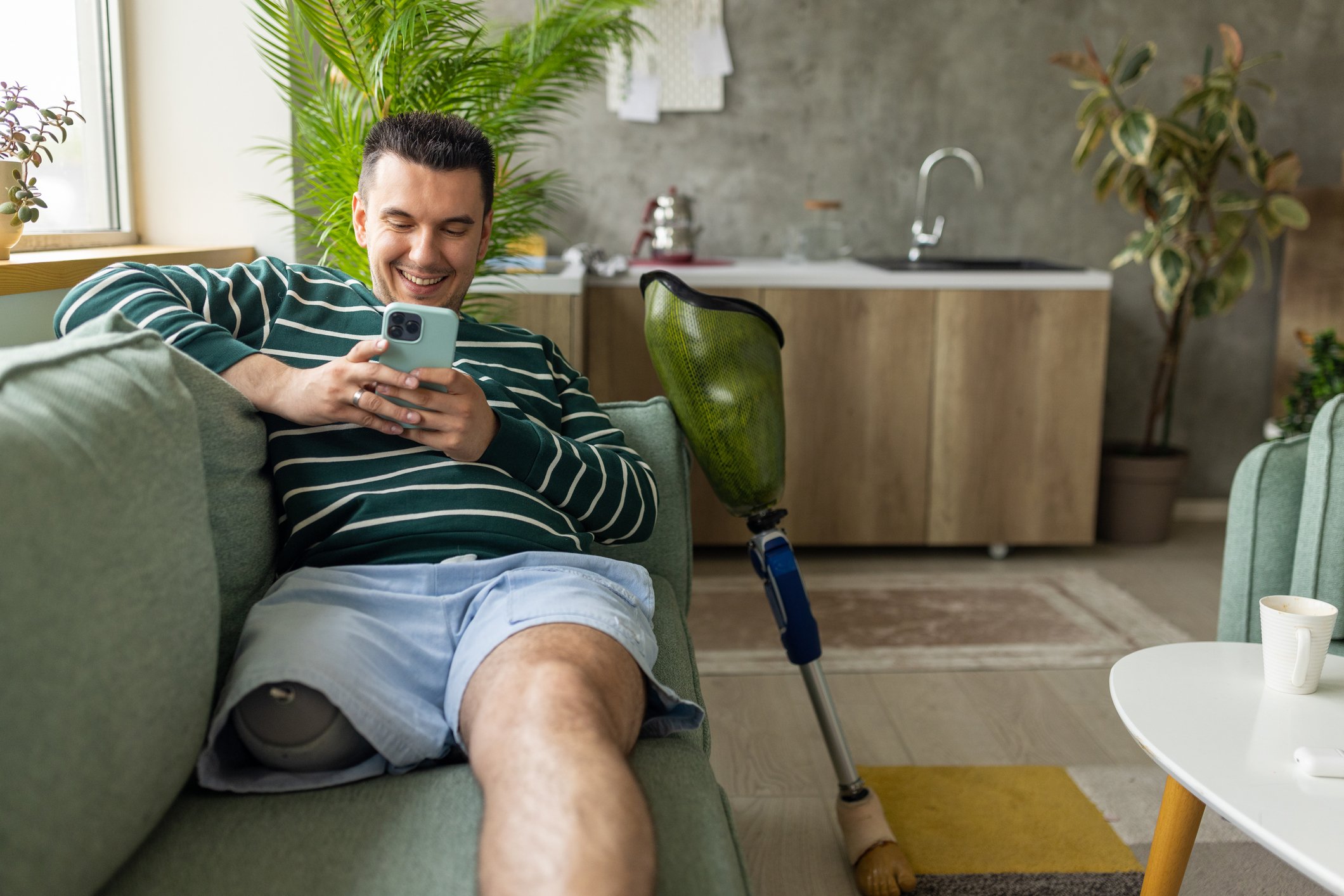 Getty - smiling at phone happy on couch