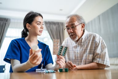 Physician giving medicine to elderly patient.