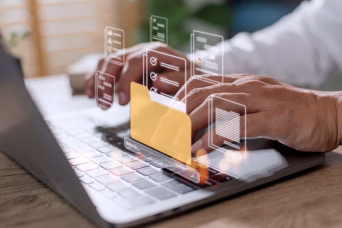 Person utilizing a computing device portrayed with an abstract representation of workplace productivity tools.