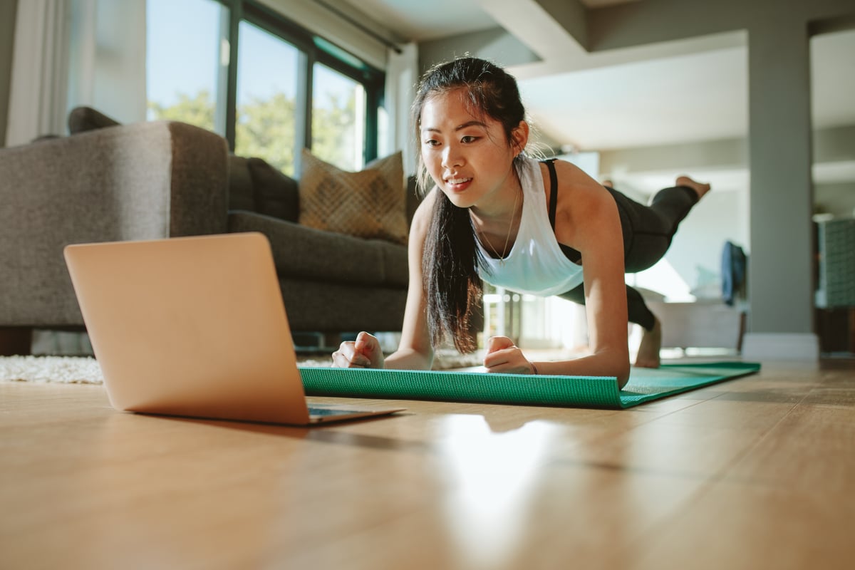 Person performing a fitness activity while observing a computing device.