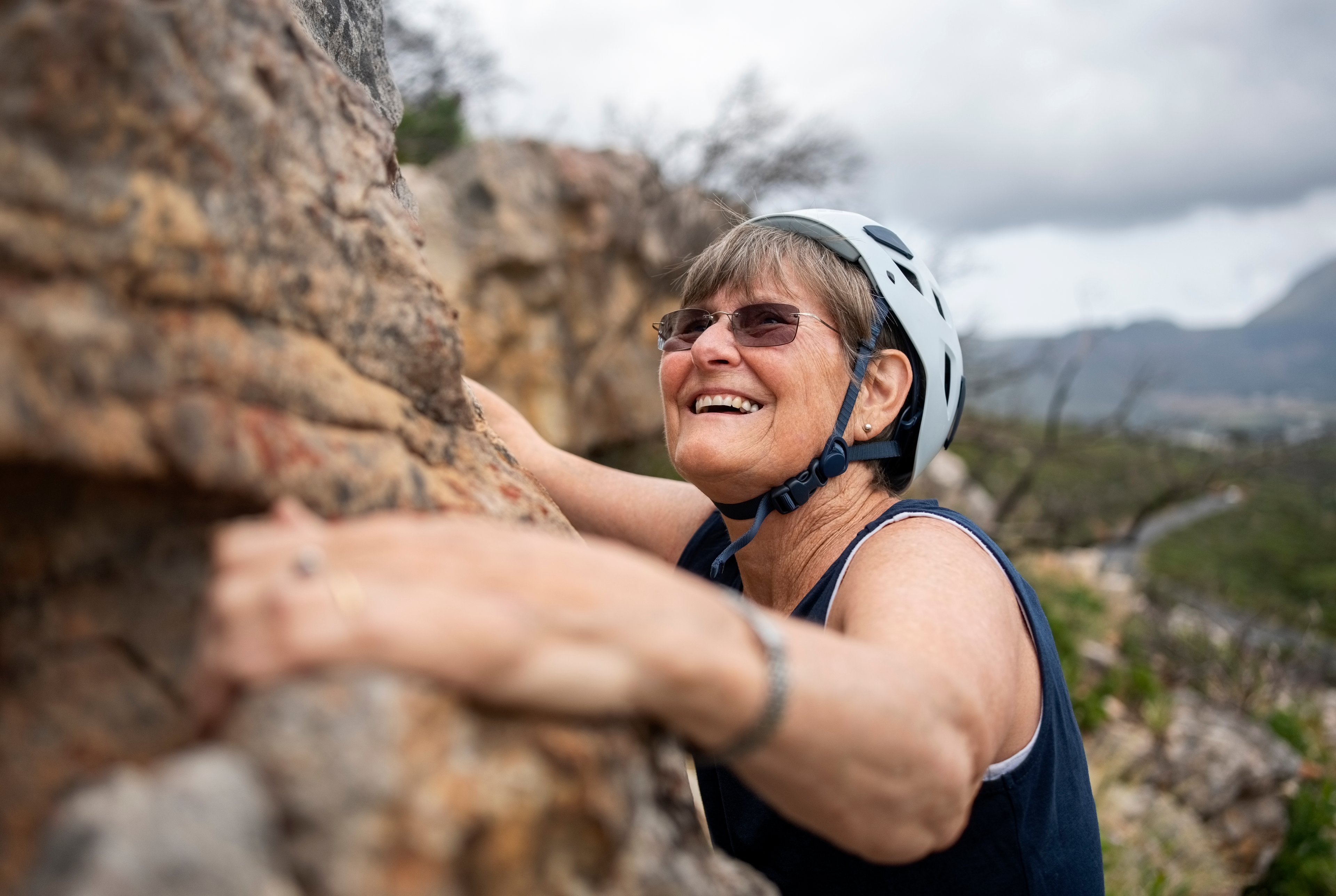 Someone rock climbing with a helmet on.