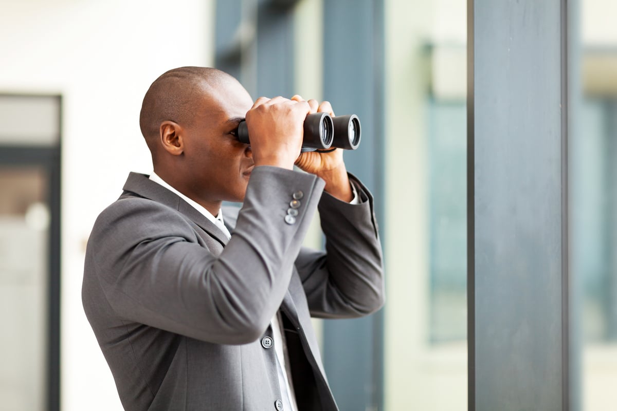 businessman uses binoculars.