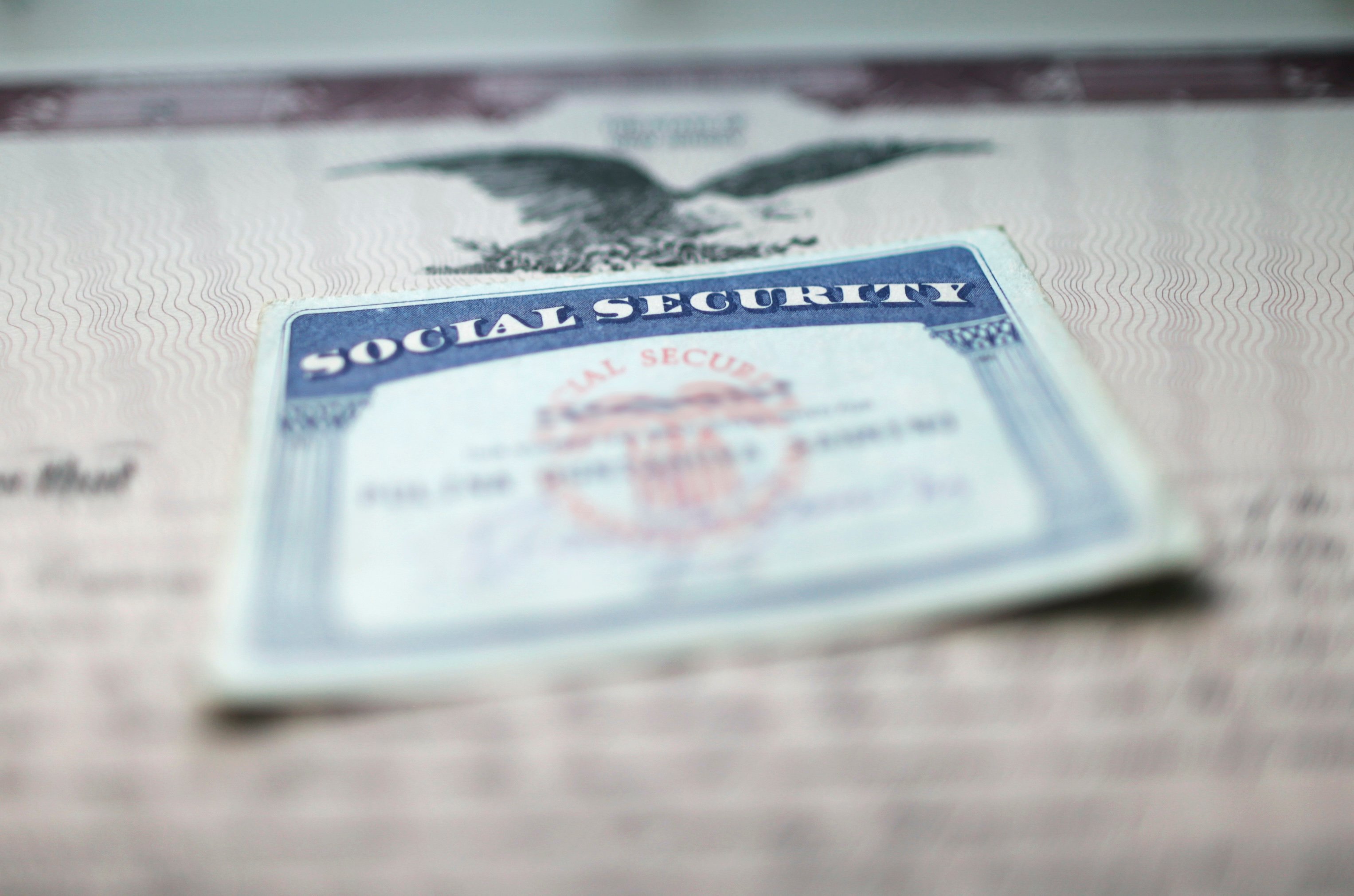 A Social Security card atop a document bearing an Eagle seal.