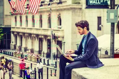 Trader with laptop on Wall Street