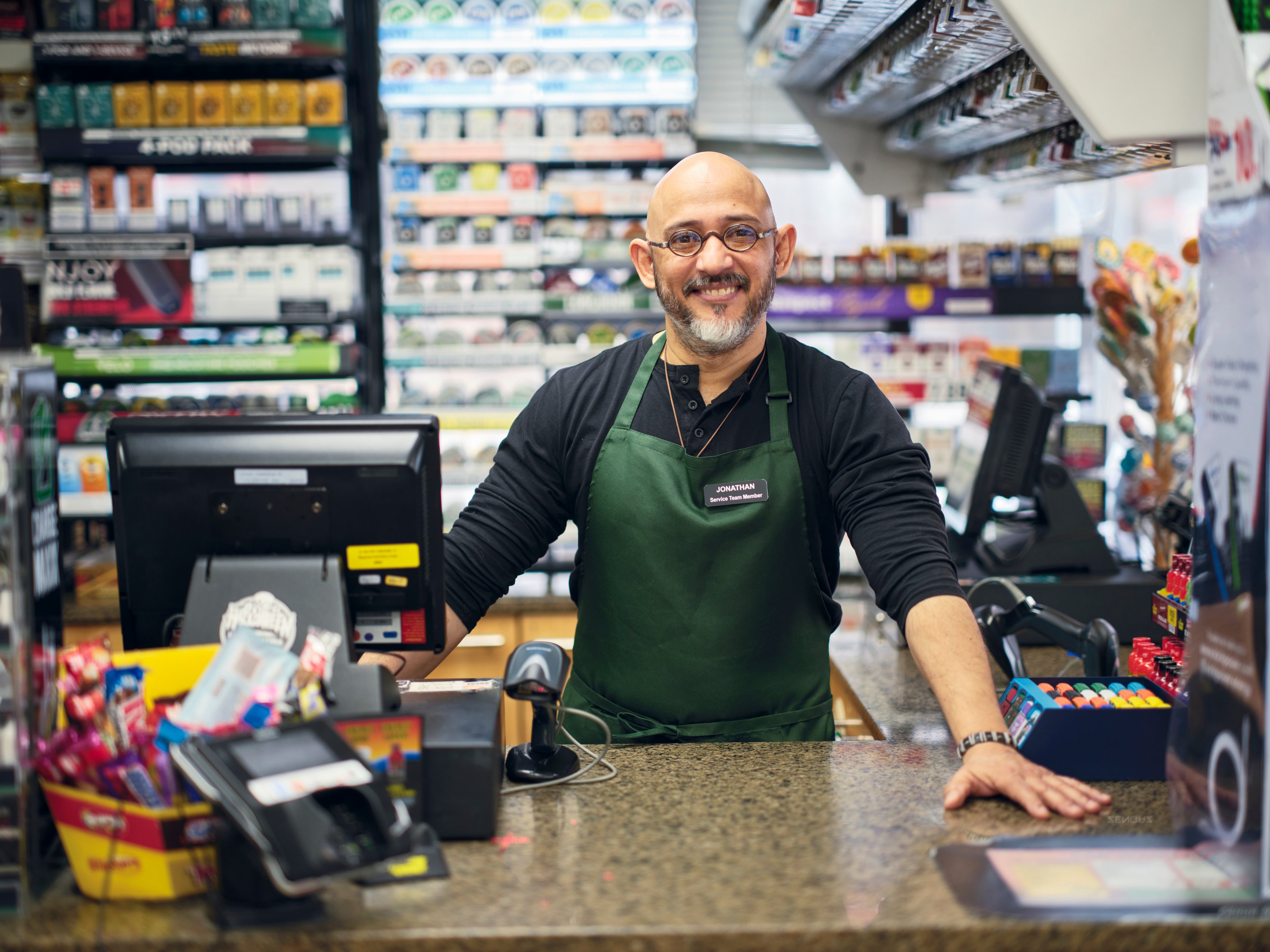 Smiling man working at convenience store.