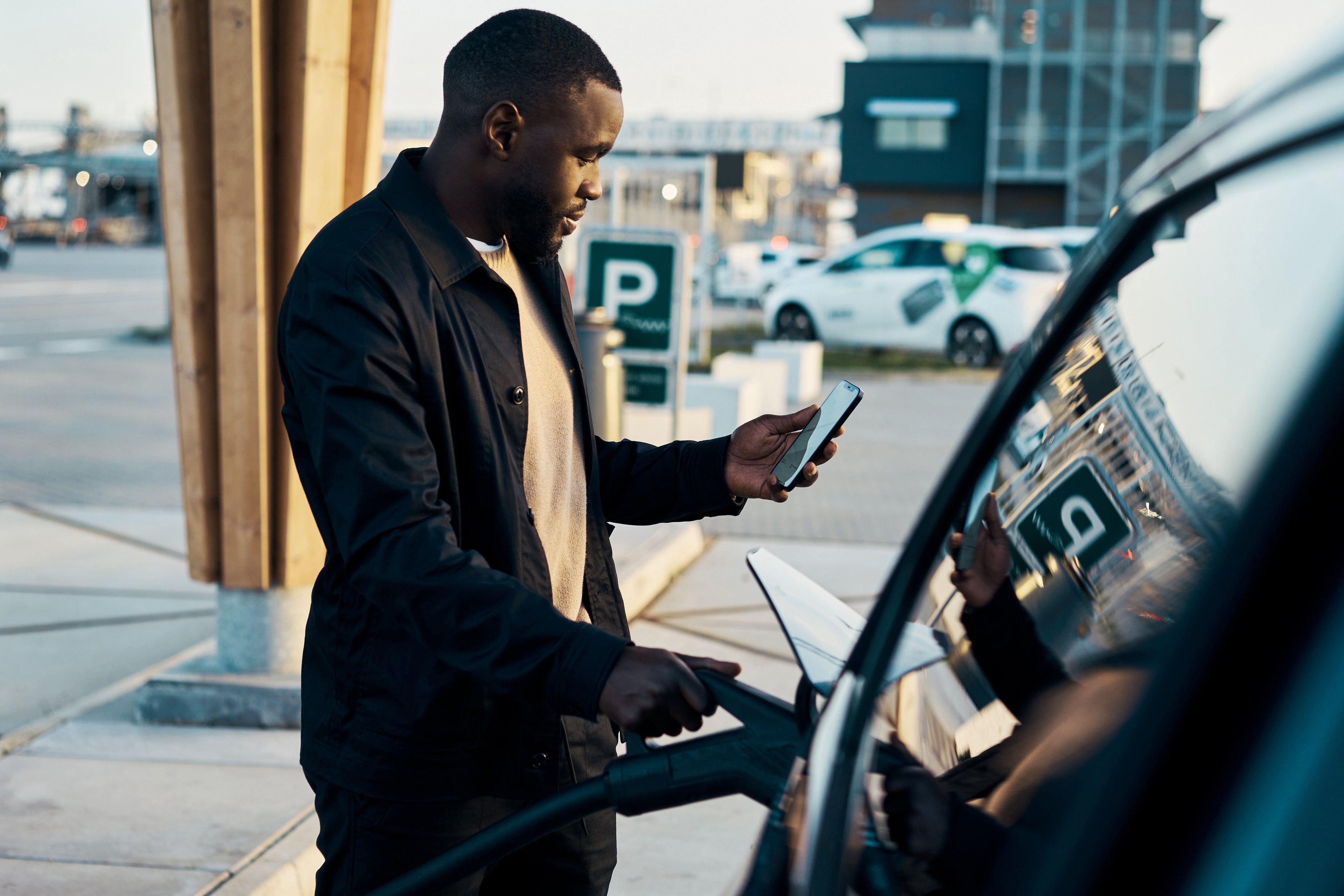 A person charges an EV at a charging stall.