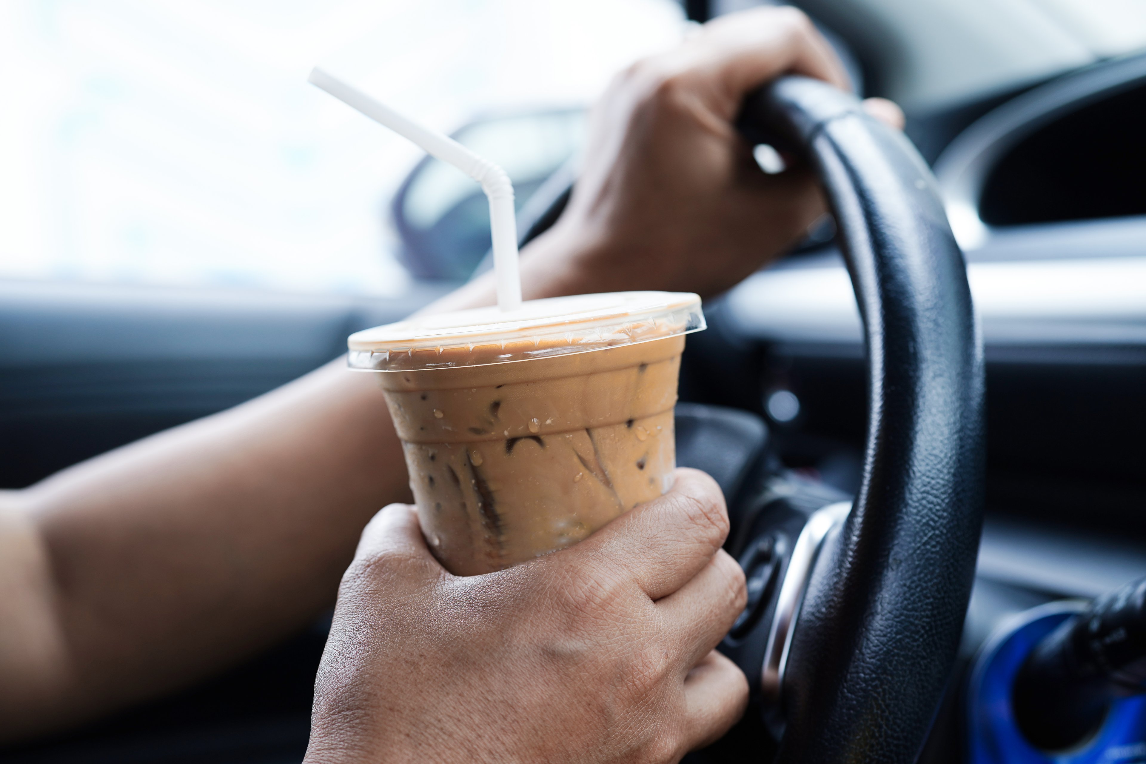 Person drinking coffee while driving.