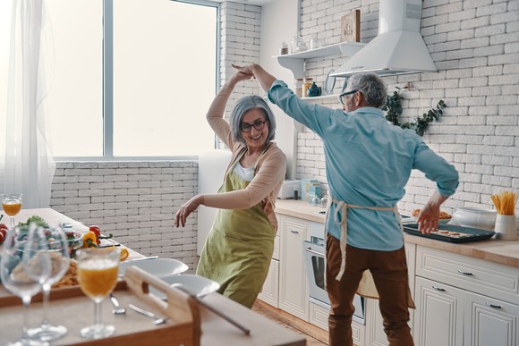 Older couple dancing in kitchen.