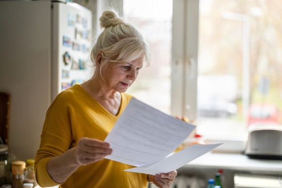 Person looking at documents in their kitchen.