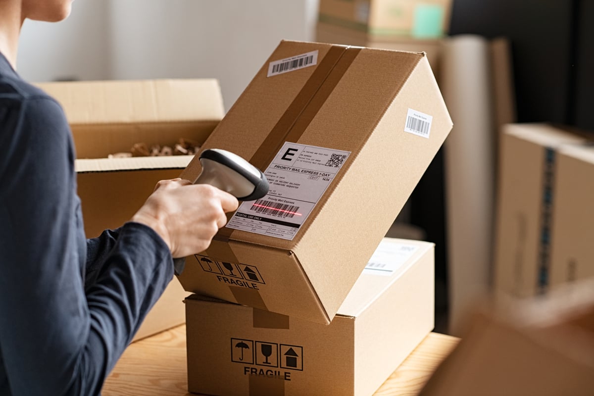 Person using a scanning device on a package barcode.