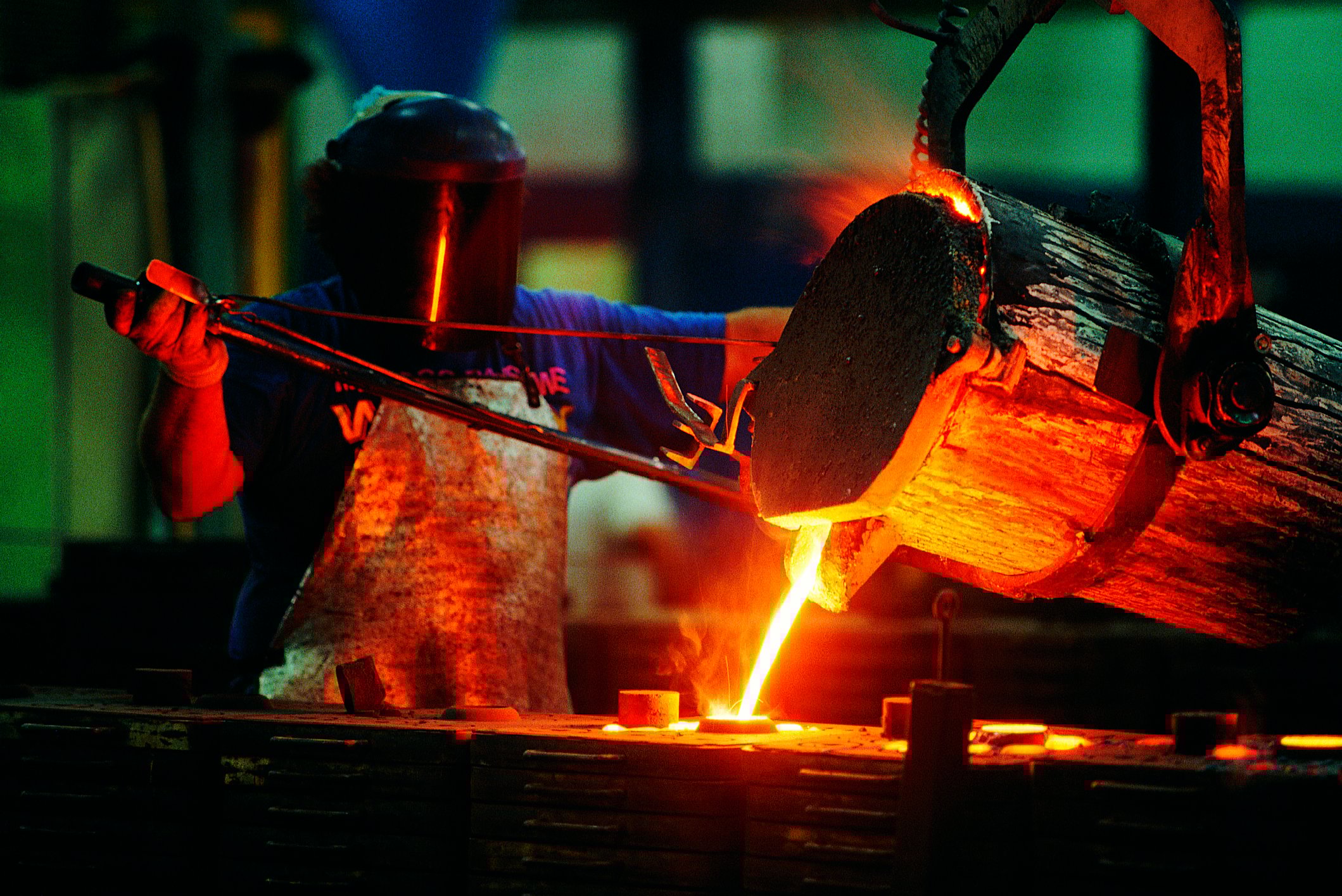 Steelworker pouring molten steel.