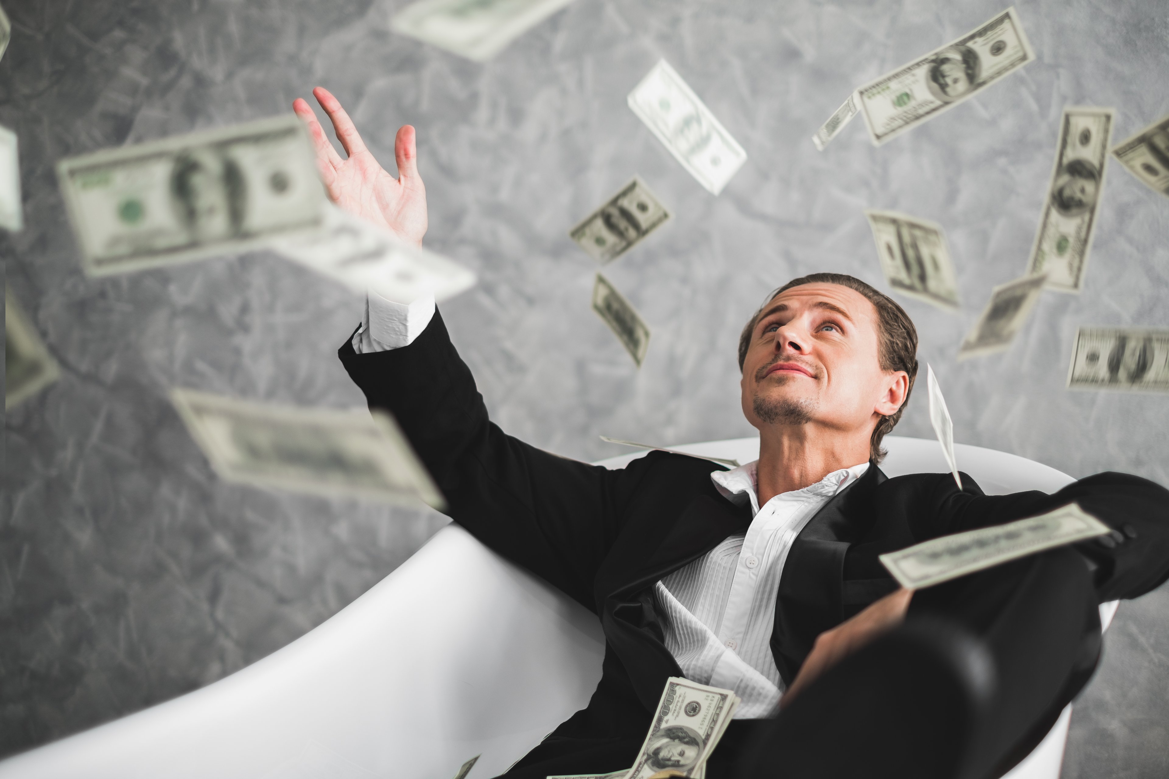man-sitting-flying-currency-notes