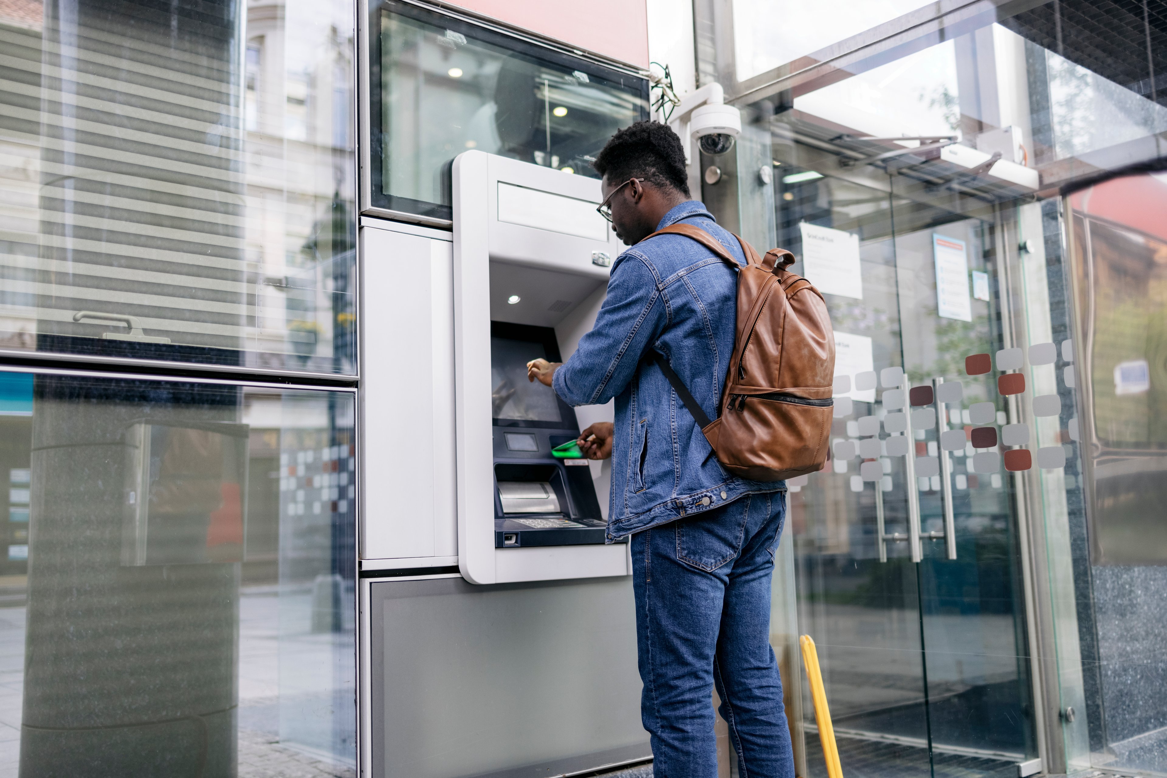 A person uses an ATM.