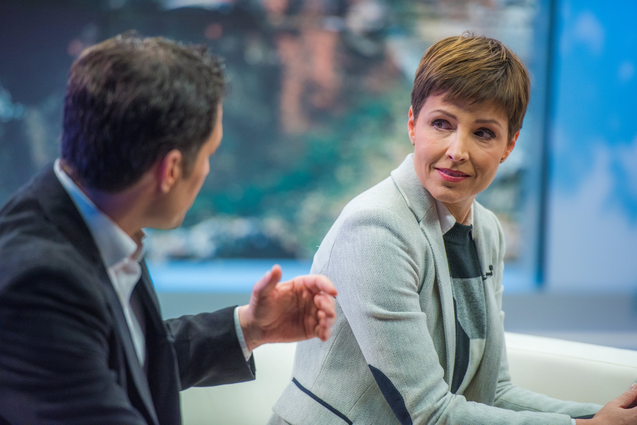 Two people talking on the set of a talk show.
