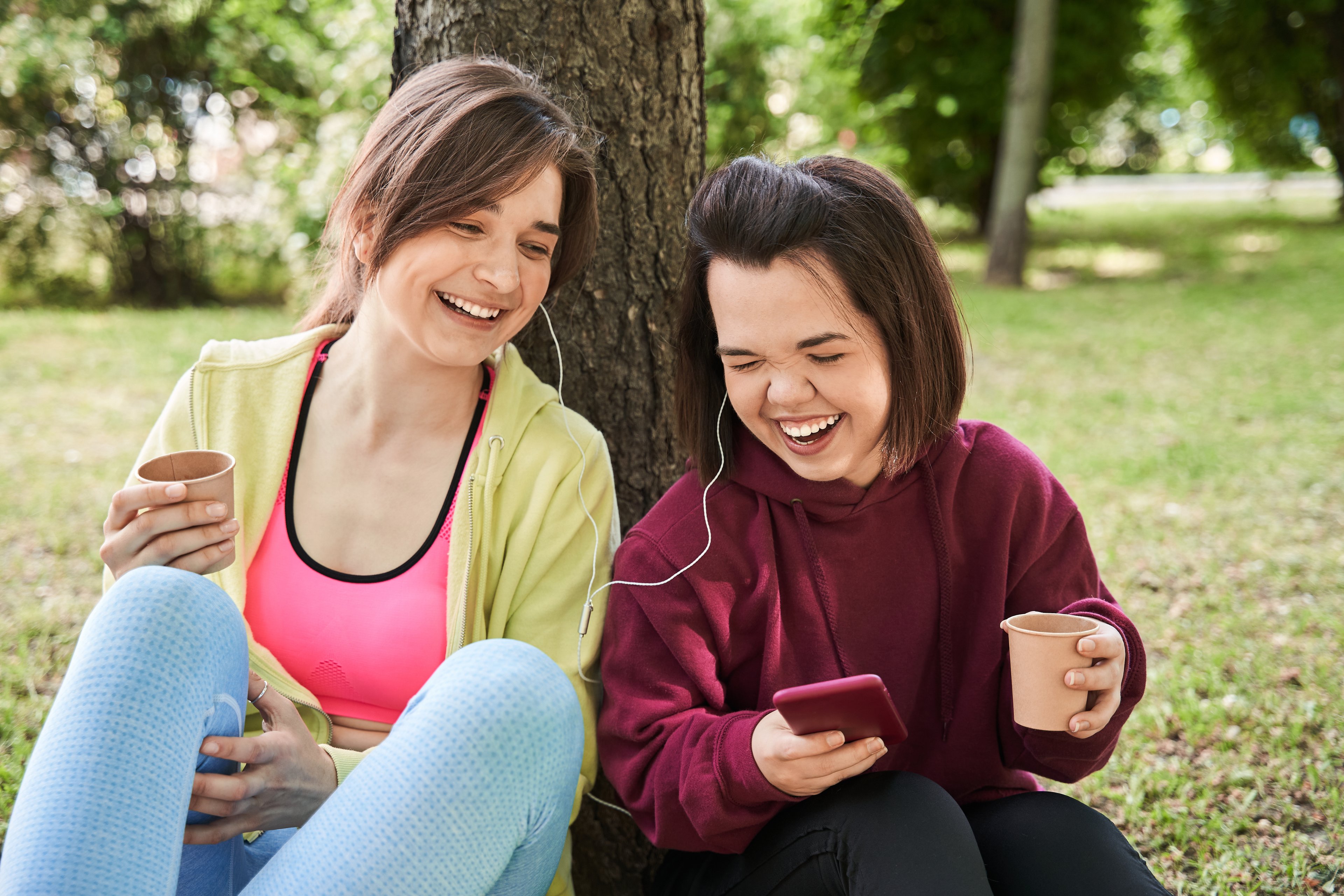 Getty - two friends happy smiling by tree