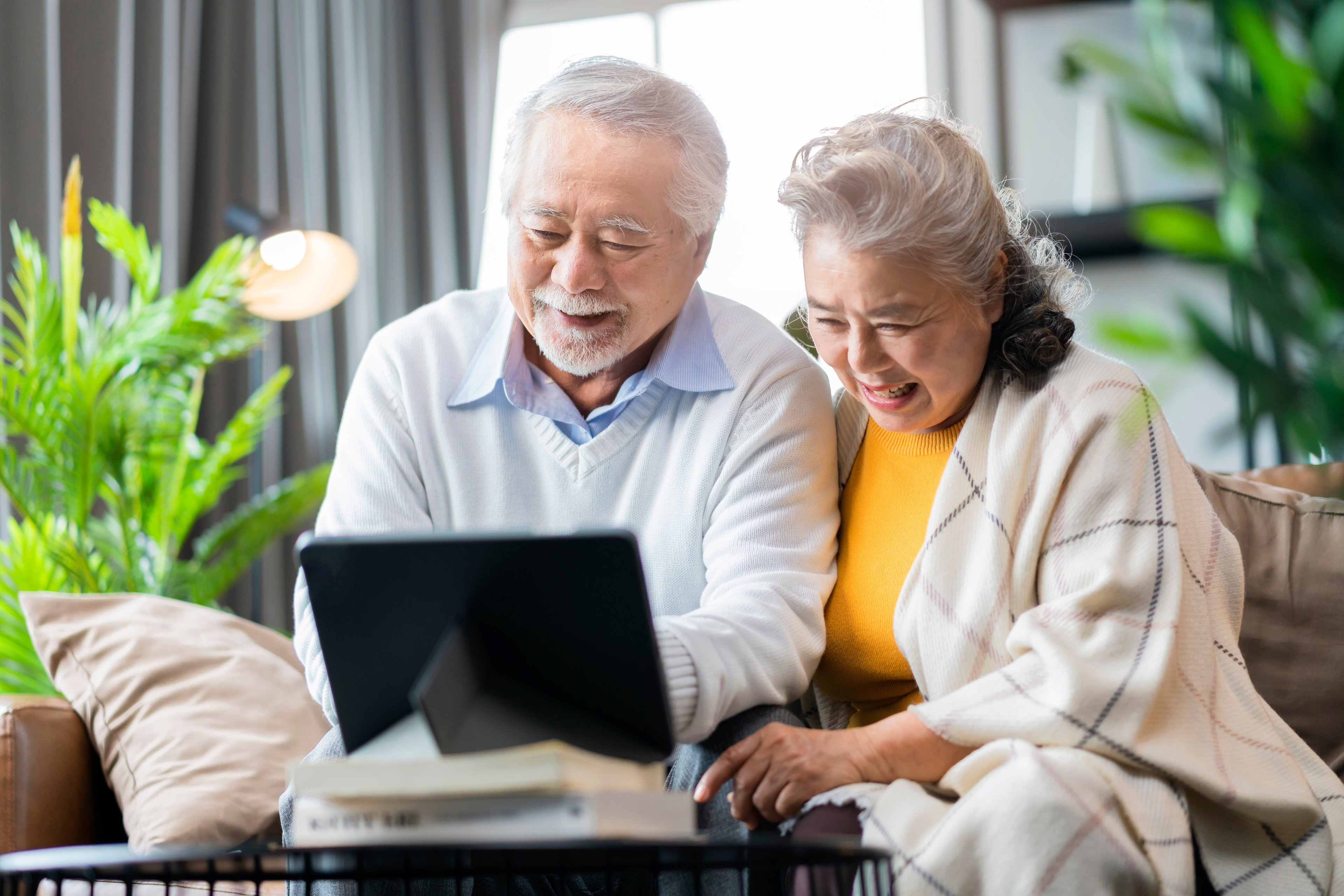Two people sitting down and looking at a laptop.
