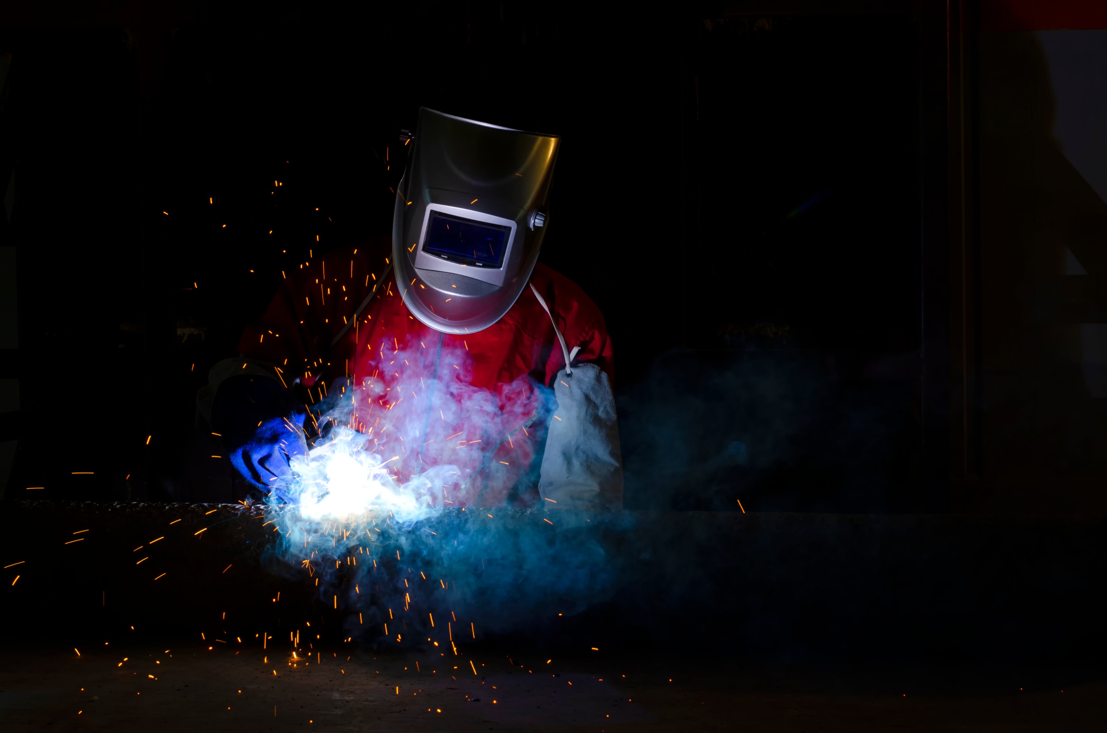 Person in protective gear using welding equipment