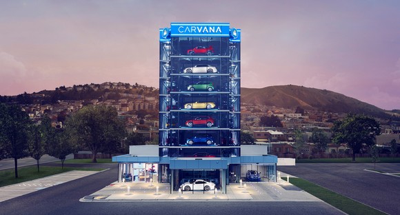 An artist rendering shows a Carvana tower with used cars in it on a lot in front of several hills