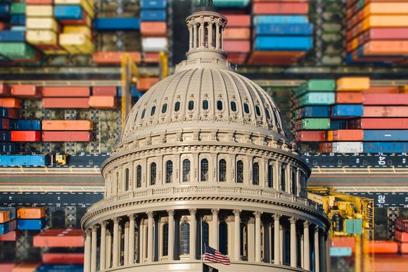 The United States capitol building against a background of shipping containers.