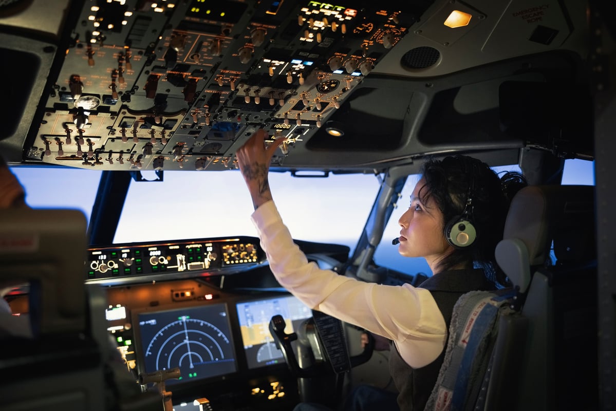Pilot adjusting controls in the cockpit.
