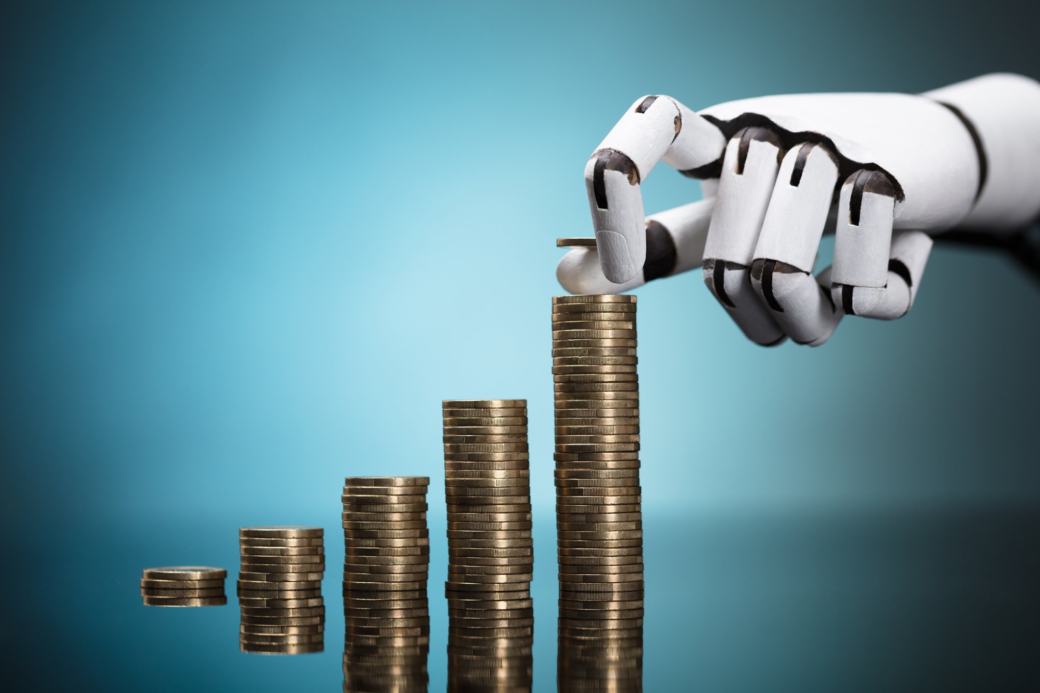 A robotic hand builds coin stacks of increasing height.