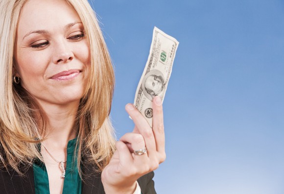 Investor holding a hundred dollar bill.