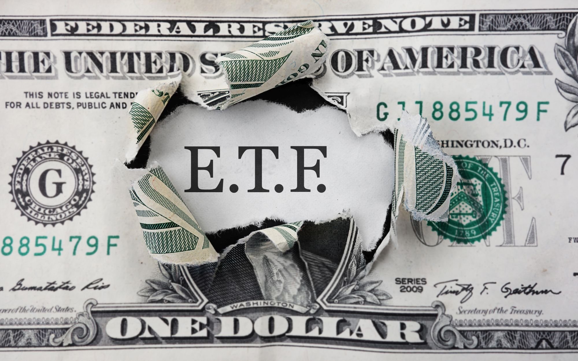 A dollar bill with ETF written behind it.