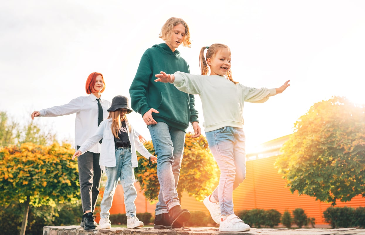 Group of 4 people walking in line while making active arm movements.