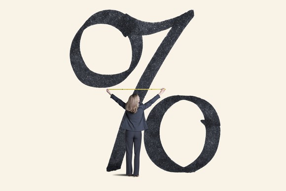 A person measuring a huge percent sign.