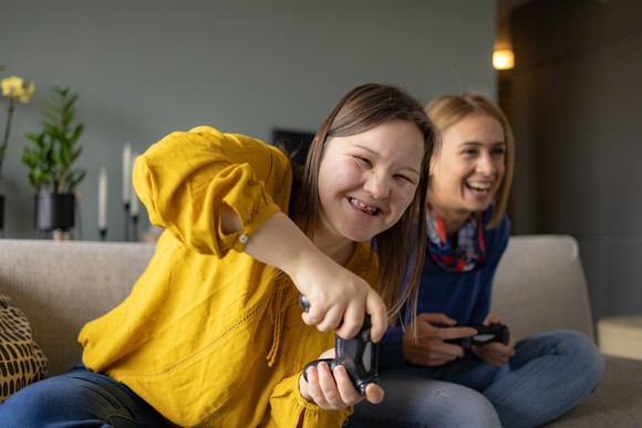 Two young people seated at a couch and enjoying a video game.