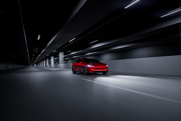 red Tesla driving fast through tunnel. 
