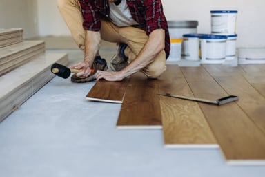 a man installs plank flooring