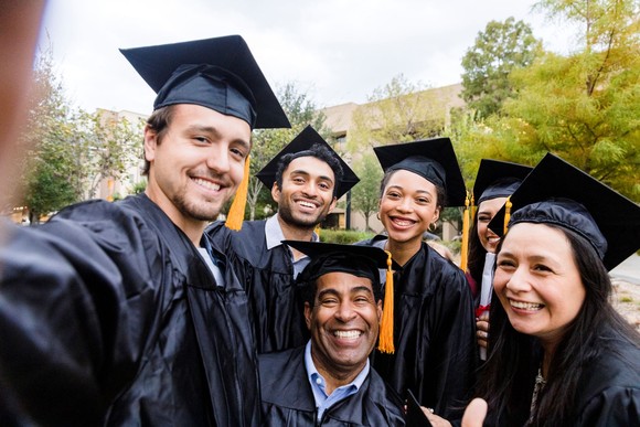 Graduates taking a picture at a graduation.